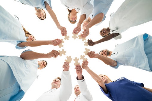 Image of Medical Team Joining Jigsaw Pieces In Huddle