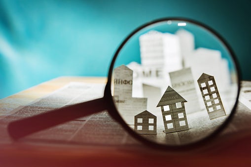 Image of paper house under a magnifying lens